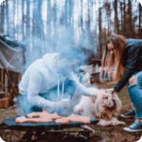 Famille avec chien faisant un BBQ